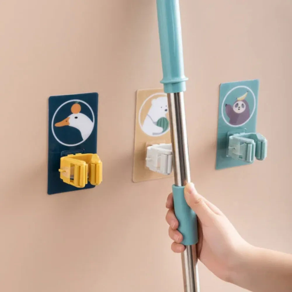 Self-adhesive broom holder