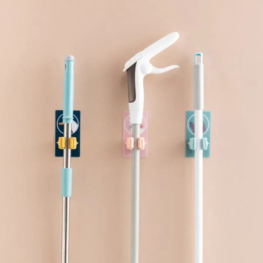 Self-adhesive broom holder